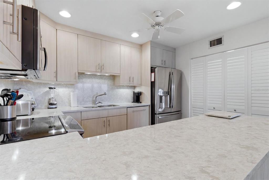 2729 North Beach Road, Unit 211 Englewood, FL 34223 - Photo 22 of 51 a kitchen with stainless steel appliances granite countertop a sink refrigerator and cabinets