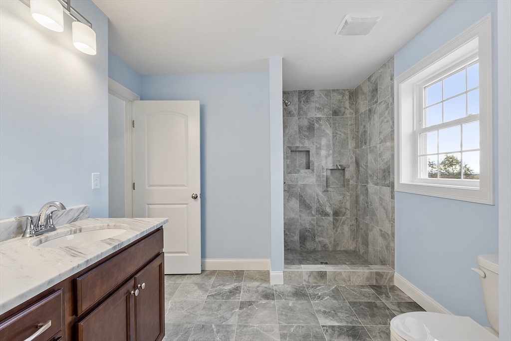 186 Justice Hill Road, Unit MOD FARM Sterling, MA 01564 - Photo 23 of 29 a bathroom with a granite countertop sink a toilet a mirror and shower