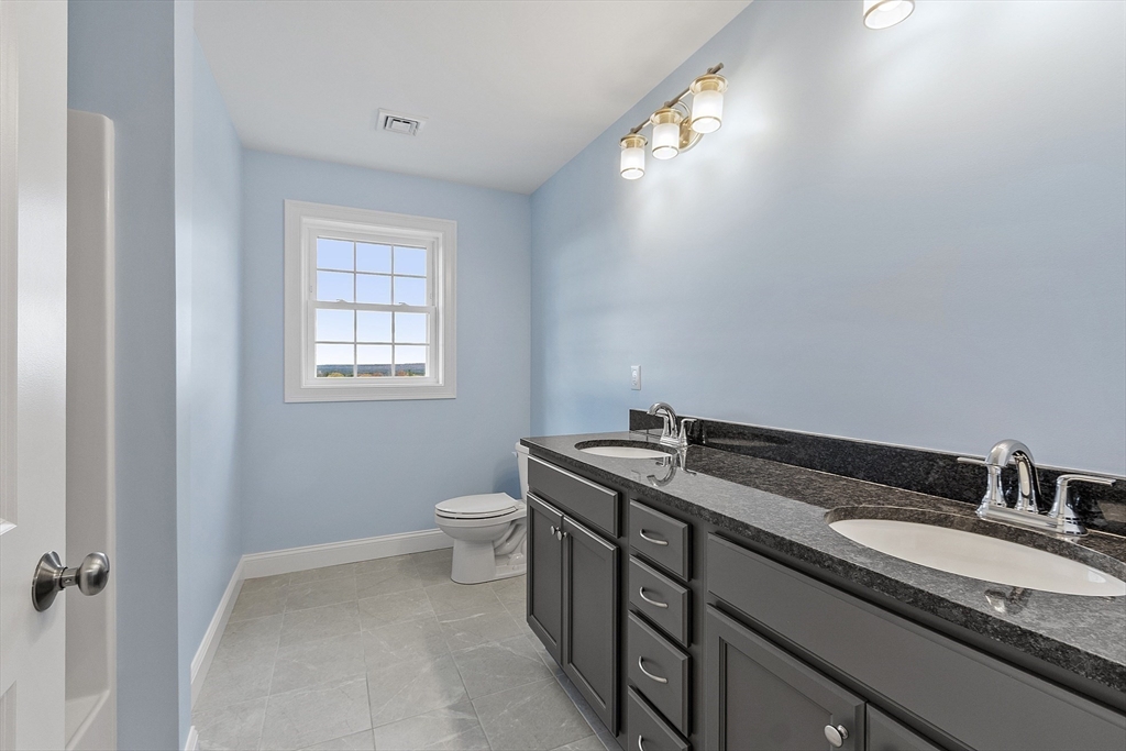 186 Justice Hill Road, Unit MOD FARM Sterling, MA 01564 - Photo 29 of 29 a bathroom with a granite countertop sink a toilet and a mirror