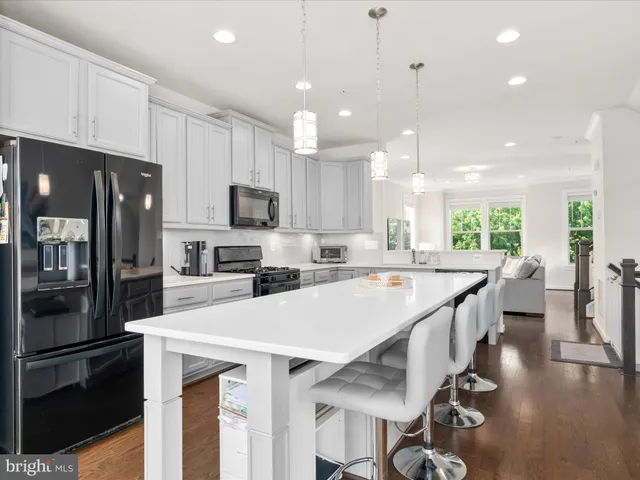 a kitchen with stainless steel appliances granite countertop a refrigerator a stove top oven a sink and a refrigerator