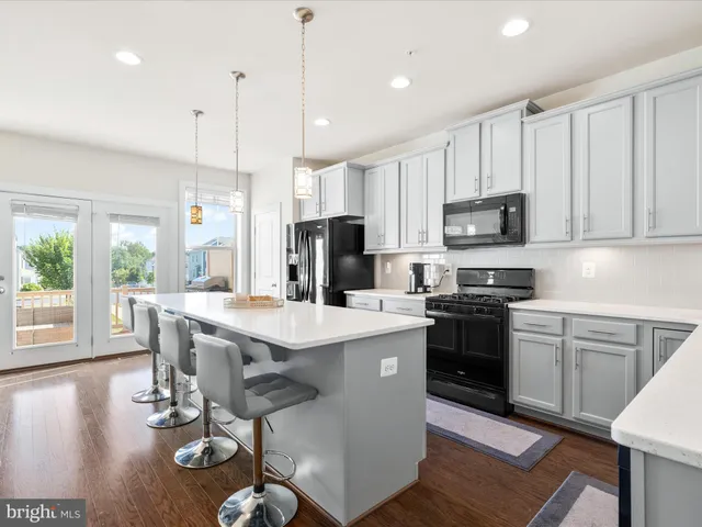 a kitchen with kitchen island granite countertop a sink a counter top space appliances and cabinets