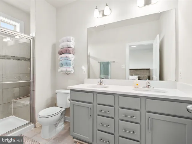 a bathroom with a toilet a sink a mirror and a shower