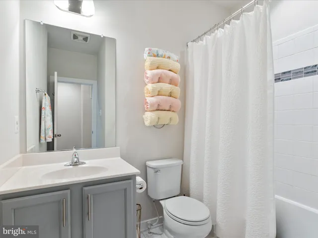 a bathroom with a sink vanity mirror and toilet