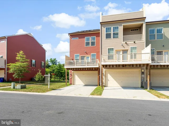 a front view of a house with a yard and potted plants