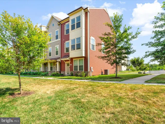 a view of a big house with a big yard and large trees