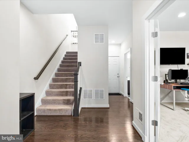 a view of a livingroom with wooden floor and staircase