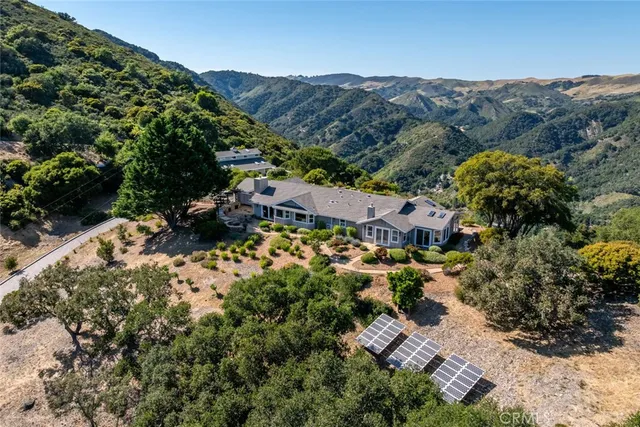 an aerial view of residential houses with outdoor space and trees