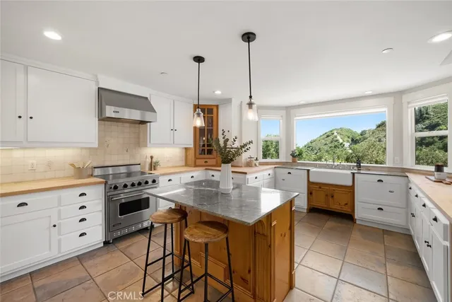 a kitchen with stainless steel appliances a dining table chairs and wooden floor