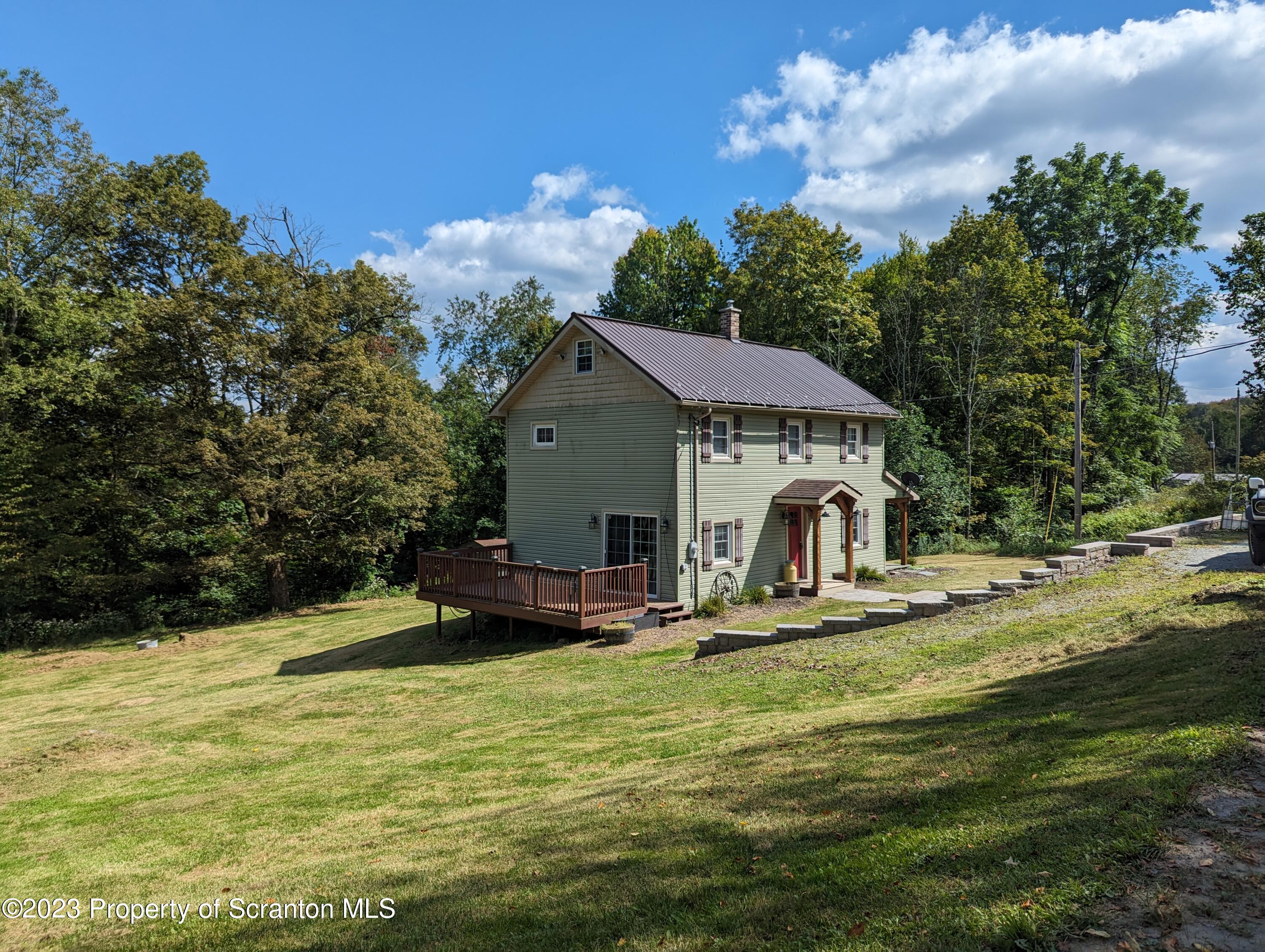 440 Tiffany Road Kingsley, PA 18826 - Photo 3 of 40 a house view with swimming pool and trees in the background