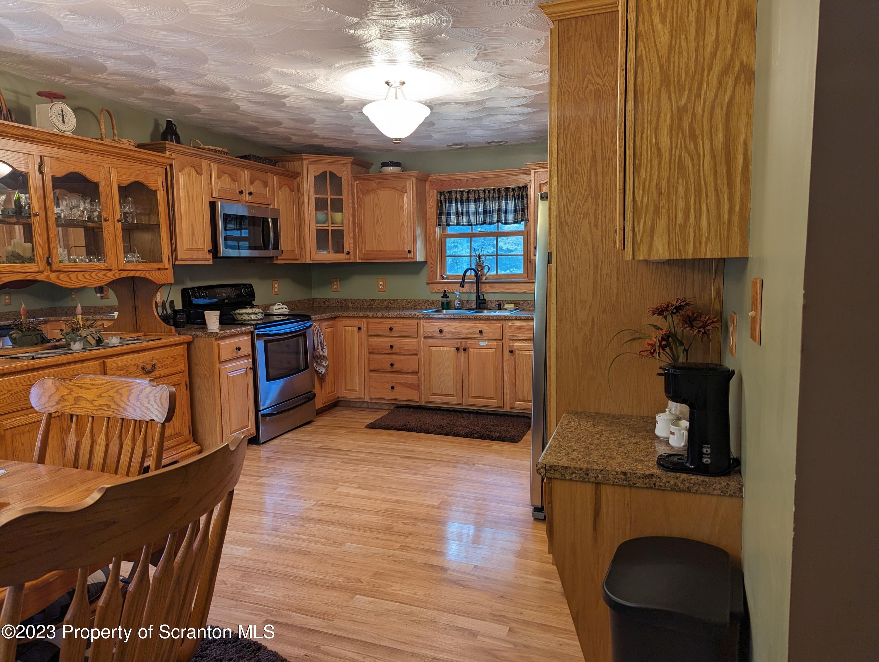 440 Tiffany Road Kingsley, PA 18826 - Photo 8 of 40 a kitchen with stainless steel appliances granite countertop a stove a sink dishwasher and a microwave oven with white cabinets