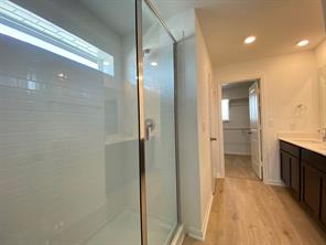 213 Saide Street Georgetown, TX 78626 - Photo 21 of 32 Glass-enclosed shower with white subway tile, integrated shelving, and a transom window