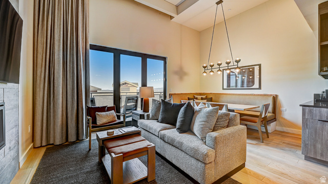 2417 West High Road, Unit 2515 Park City, UT 84098 - Photo 5 of 67 Living area featuring a high ceiling, light wood-type flooring, and a glass covered fireplace