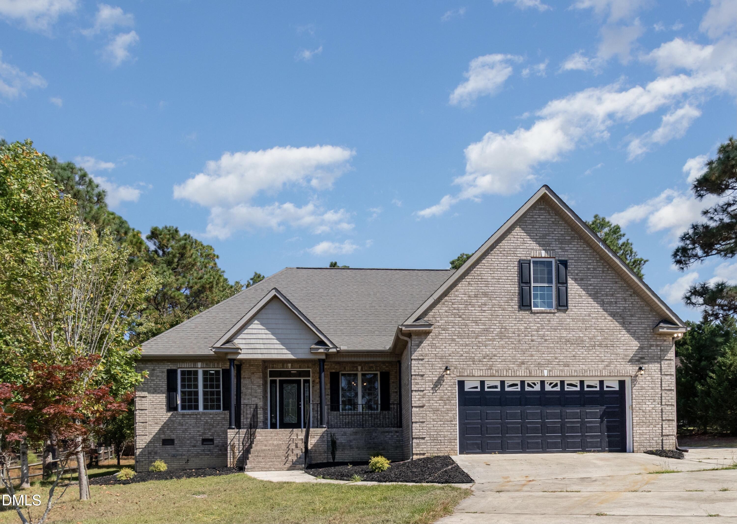 42 Racquet Court Sanford, NC 27332 - Photo 2 of 23 a front view of a house with a garden and yard