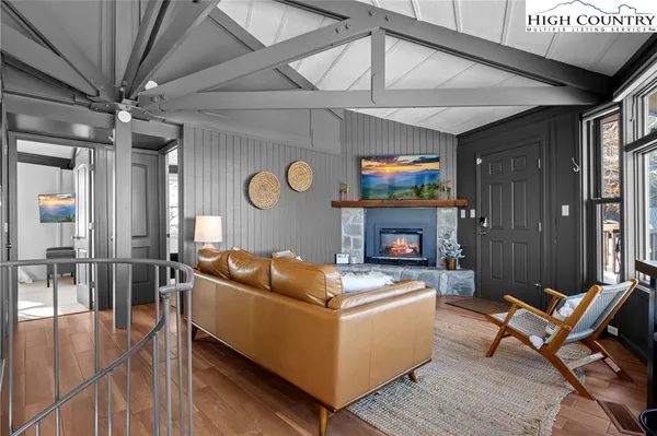 a living room with furniture fireplace and a large window