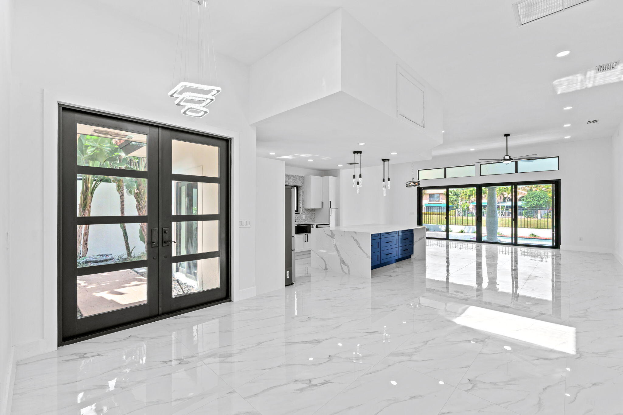 6567 Via Benita Boca Raton, FL 33433 - Photo 16 of 63 a view of a big room with windows and chandelier