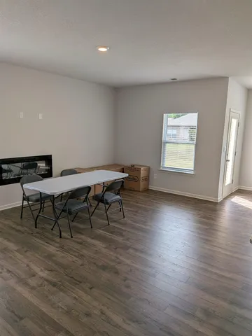 a view of a work space with wooden floor and a window