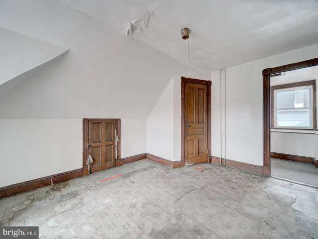 a view of an empty room with closet and a window
