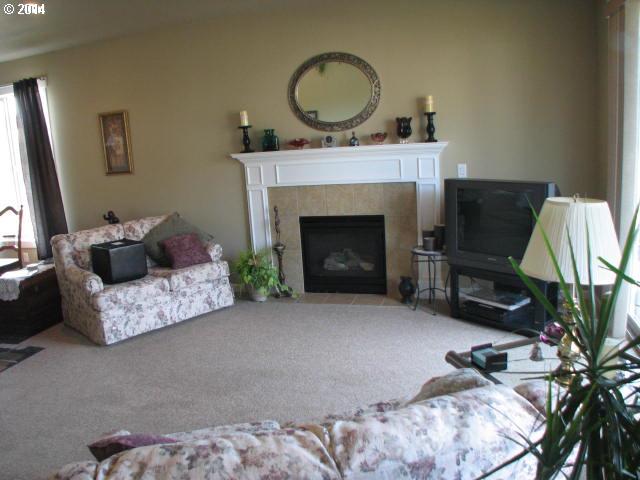 3702 North 3rd Circle Ridgefield, WA 98642 - Photo 6 of 16 a living room with furniture a fireplace and a flat screen tv