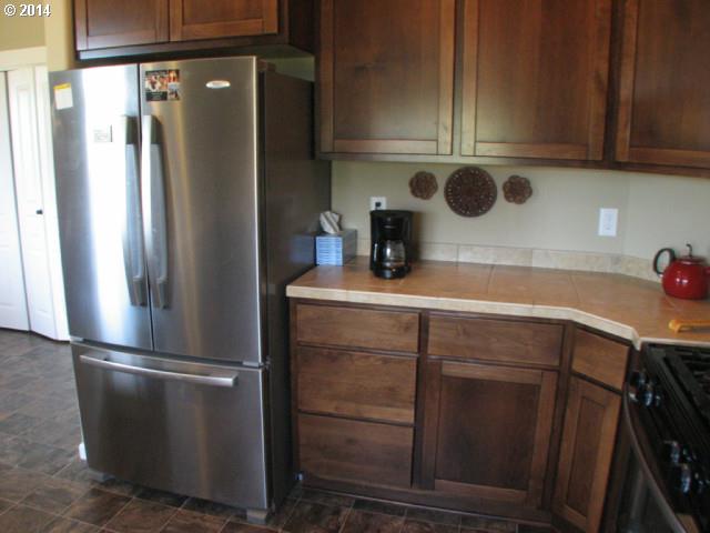 3702 North 3rd Circle Ridgefield, WA 98642 - Photo 8 of 16 a kitchen with a refrigerator and cabinets