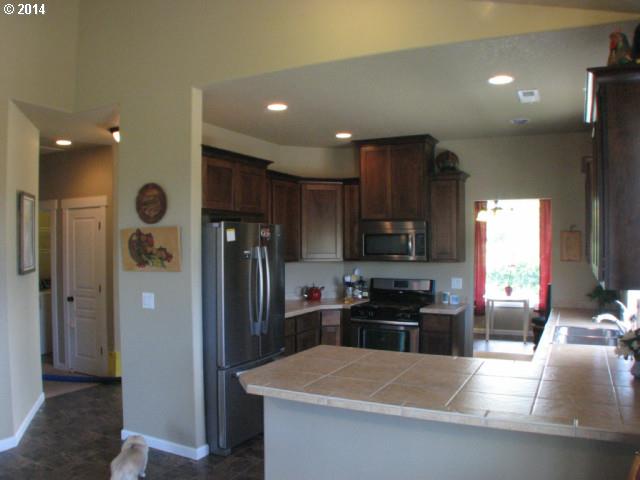 3702 North 3rd Circle Ridgefield, WA 98642 - Photo 9 of 16 a kitchen with stainless steel appliances granite countertop a refrigerator a stove and a sink