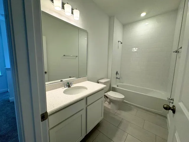 a bathroom with a double vanity sink a toilet and shower