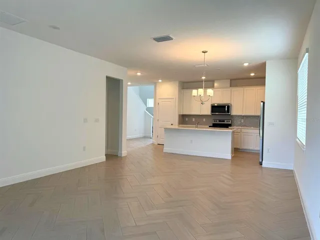 a view of kitchen with kitchen island and stainless steel appliances