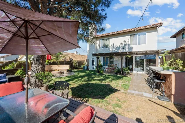 a view of a house with backyard sitting area and swimming pool