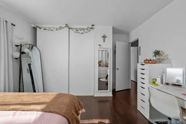 a bedroom with a bed and a wooden floor