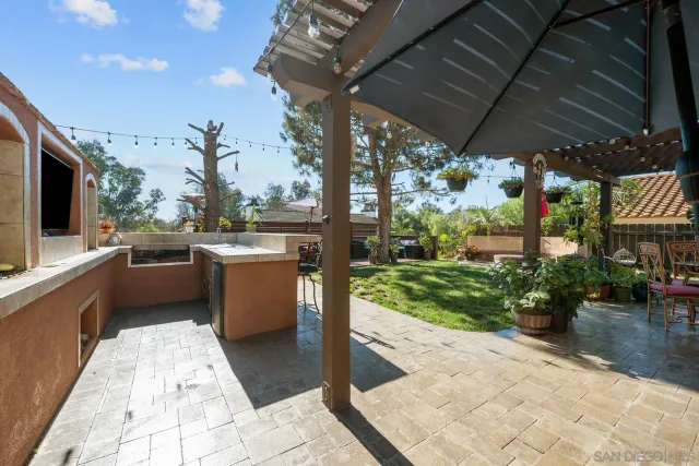 a view of a patio with a table and chairs under an umbrella