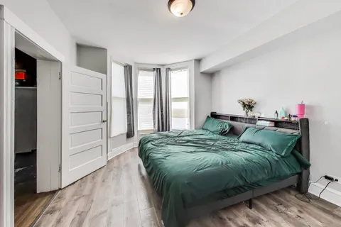 a bed sitting in a bedroom next to a window