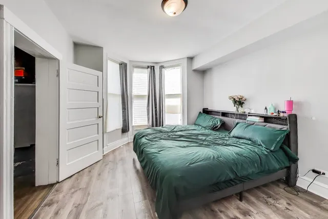 a bed sitting in a bedroom next to a window