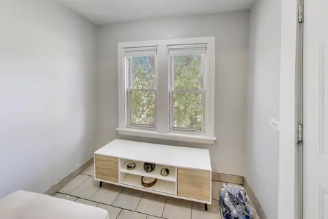 a view of an empty room with glass door and windows