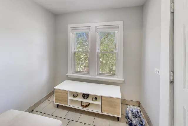 a view of an empty room with glass door and windows