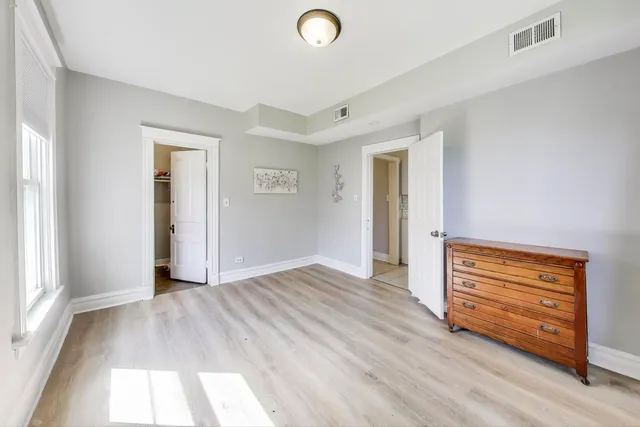 a bedroom with two beds and a chair