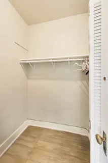 a view of a room with bed and wooden floor