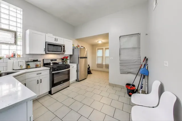 a kitchen with stainless steel appliances kitchen island granite countertop a refrigerator and a stove top oven
