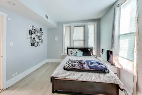 a bed sitting in a bedroom next to a window