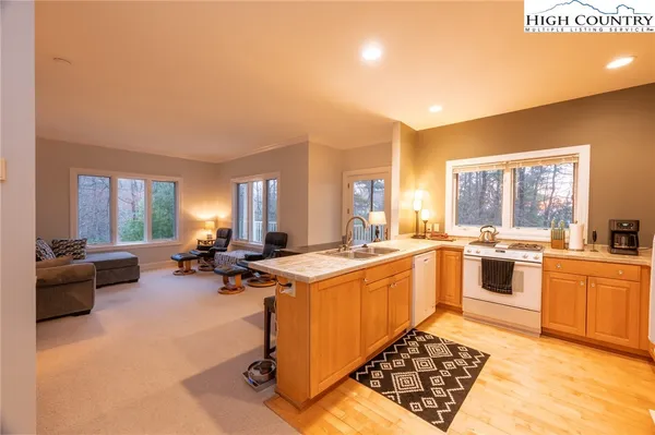 a large kitchen with a sink a counter top space stainless steel appliances and a window