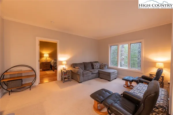 a living room with furniture and floor to ceiling windows