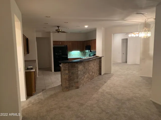 an empty room with a kitchen and a fireplace