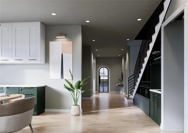 a hallway with wooden floor stairs and furniture