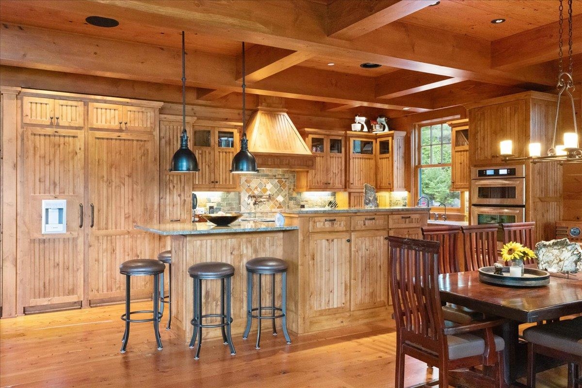 3231 Wolf Lake Road Ely, MN 55731 - Photo 8 of 50 Kitchen with beamed ceiling, stainless steel double oven, light wood-type flooring, and pendant lighting