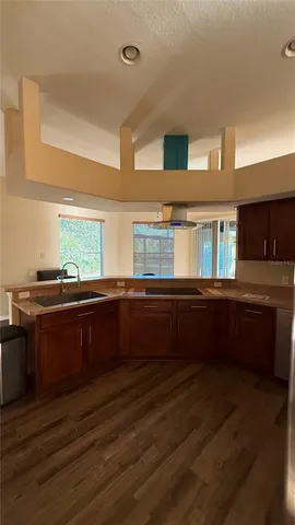 a kitchen with granite countertop wooden cabinets and a wooden floor