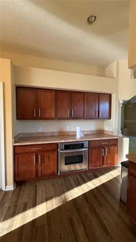a kitchen with stainless steel appliances wooden cabinets and a counter top space