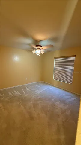 a view of a room with a window and ceiling fan