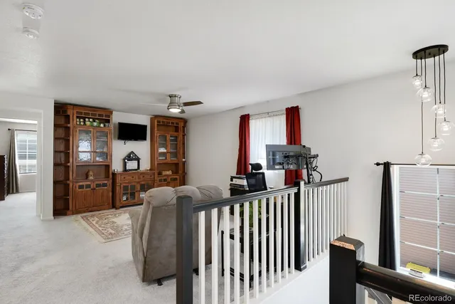 a living room with stainless steel appliances kitchen island granite countertop a refrigerator and a television