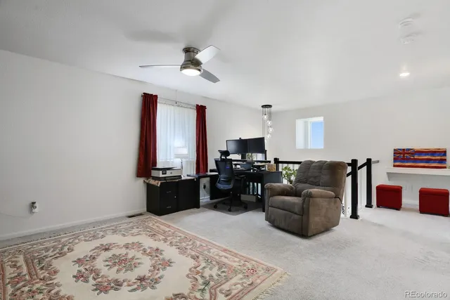 a bedroom with a large bed and a chandelier fan