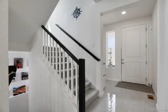 a view of a hallway with white walls and stairs