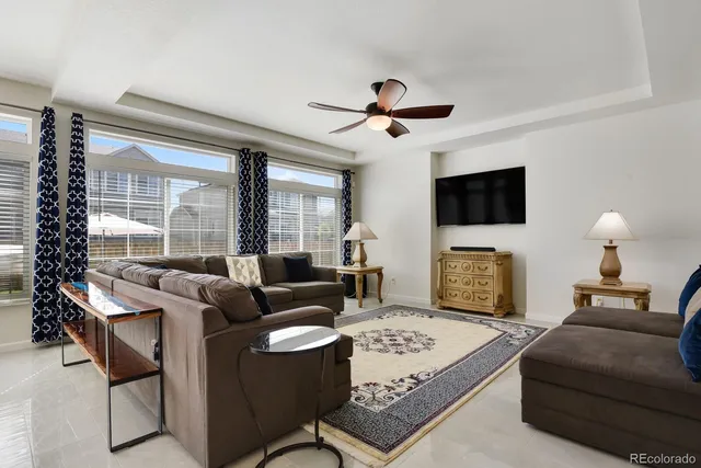 a living room with furniture a flat screen tv and a large window