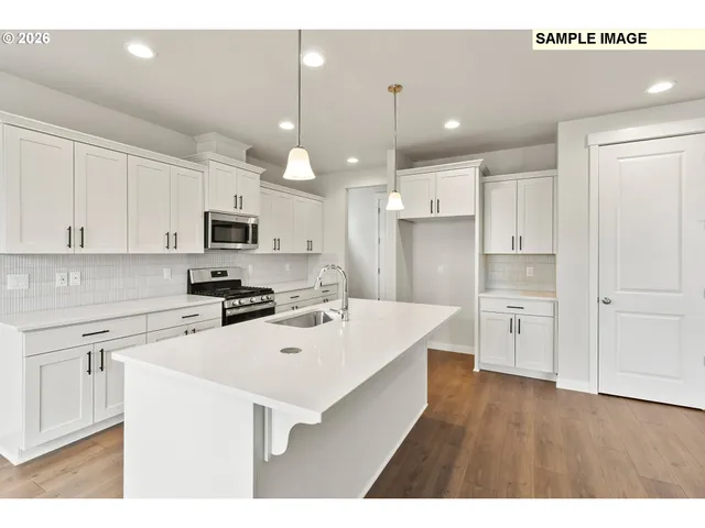a kitchen with white cabinets and refrigerator